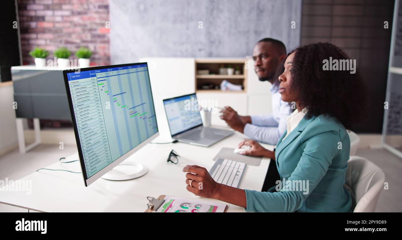 Young Businesspeople Analyzing Gantt Chart Stock Photo