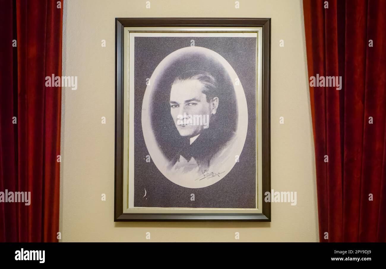 A photographic portrait of Mustafa Kemal Ataturk, the revered founder and first president of modern Turkey, flanked by red velvet curtains in the Atat Stock Photo