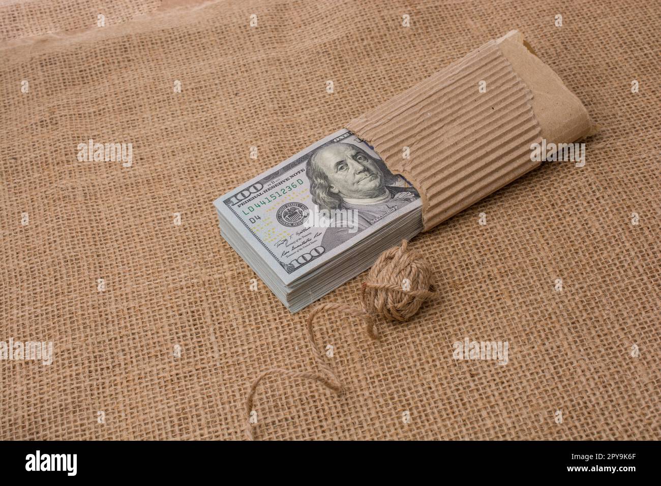 Spool of linen spool is placed on bundle of US dollar banknotes Stock ...