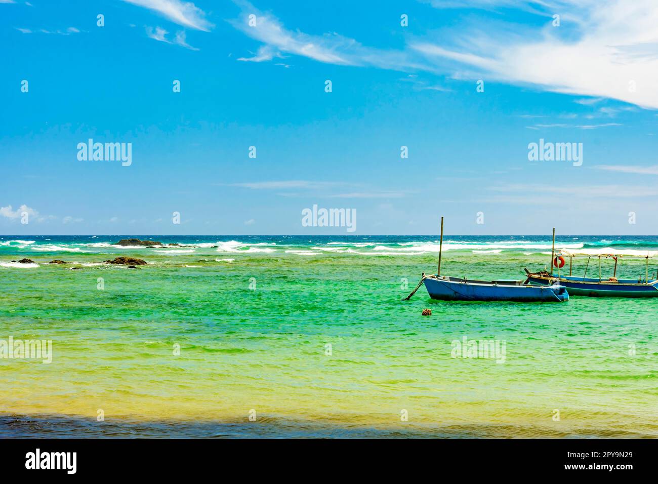 Boats on the waters of the paradisiacal beach of Itapua in the city of Salvador in Bahia, Brasil Stock Photo