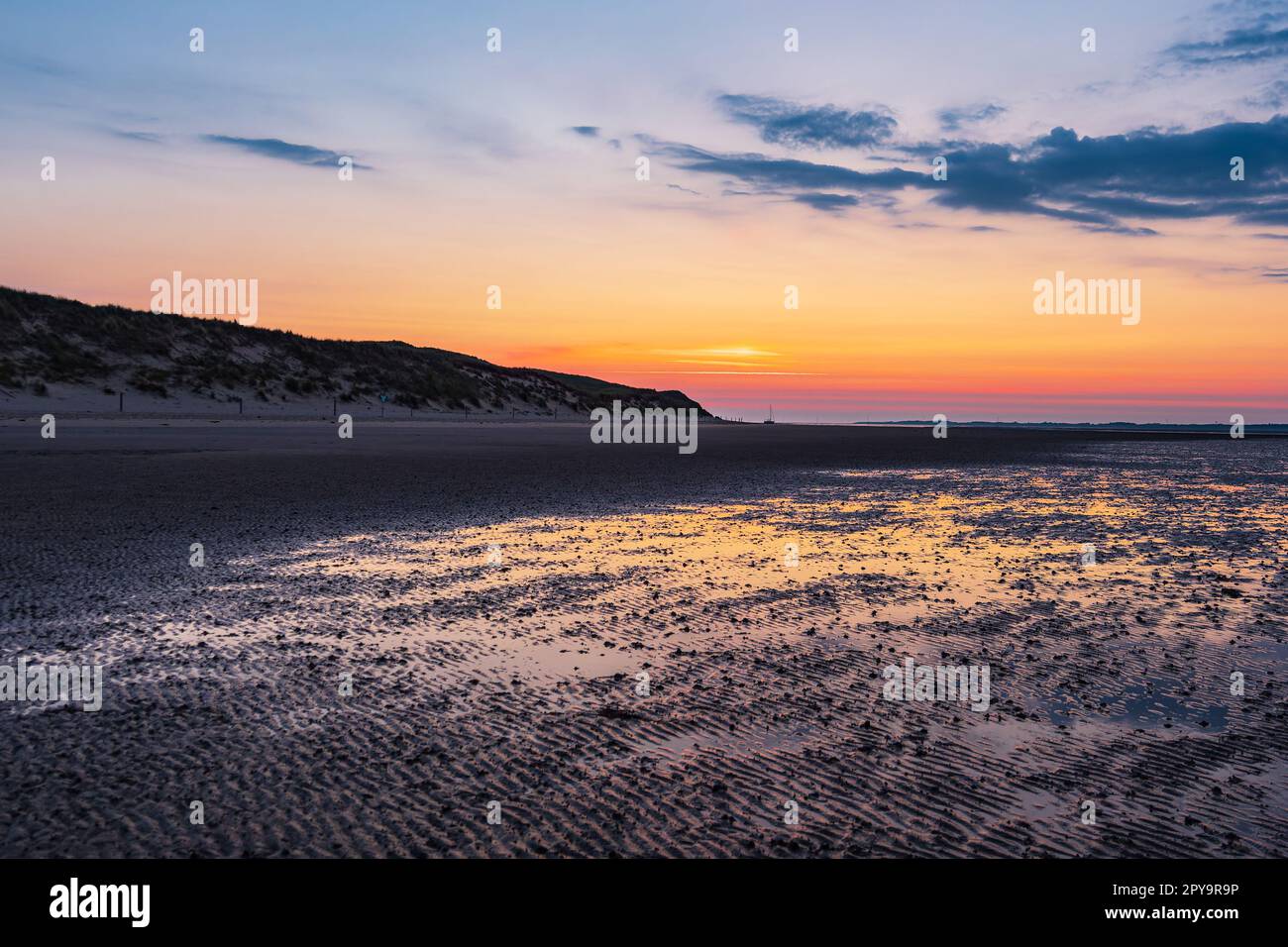 Mud flat with sunrise on the island Amrum, Germany Stock Photo