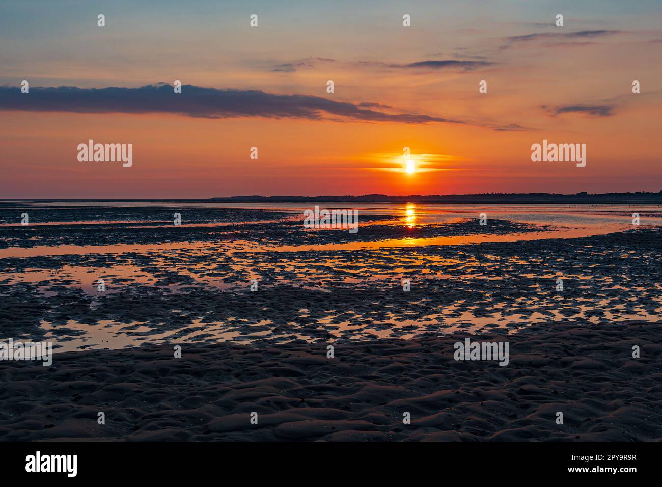 Mud flat with sunrise on the island Amrum, Germany Stock Photo