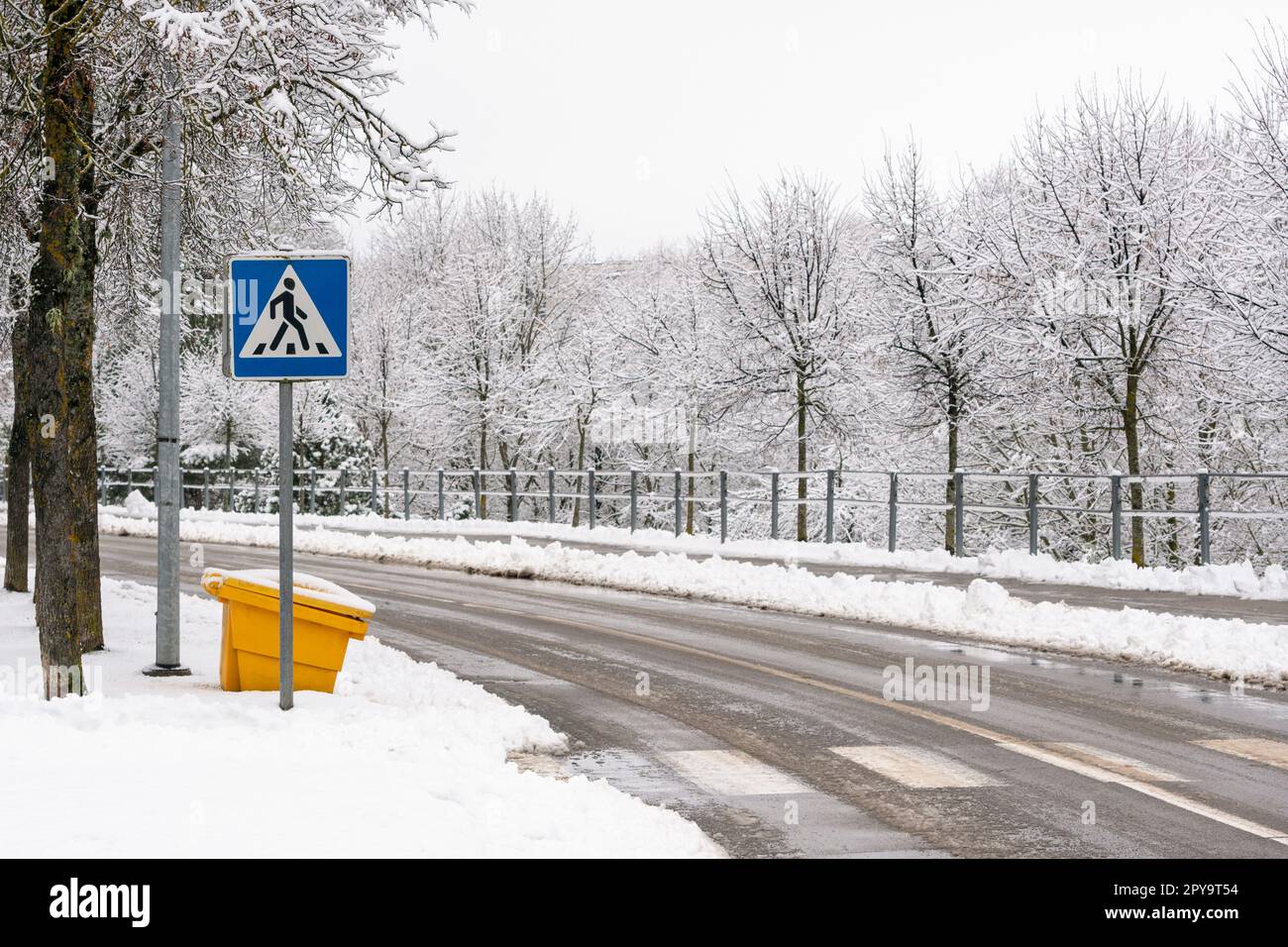 Blue crosswalk road sign and pedestrian crossing marking on the asphalt Stock Photo