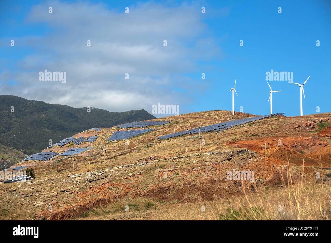 View of a sustainable farm, with photovoltaic solar panels and wind turbines, for the production of green alternative energy, the energy of the future Stock Photo