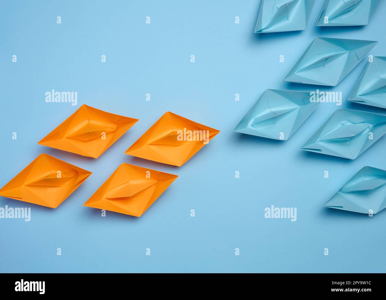 Two groups of paper boats facing each other, a concept of confrontation Stock Photo