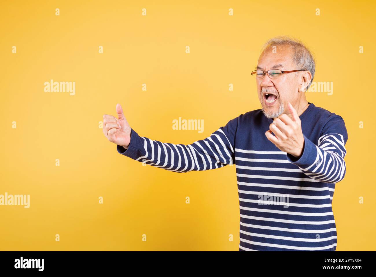 Happy Asian elder man with glasses excited say yes gesture like winner Stock Photo