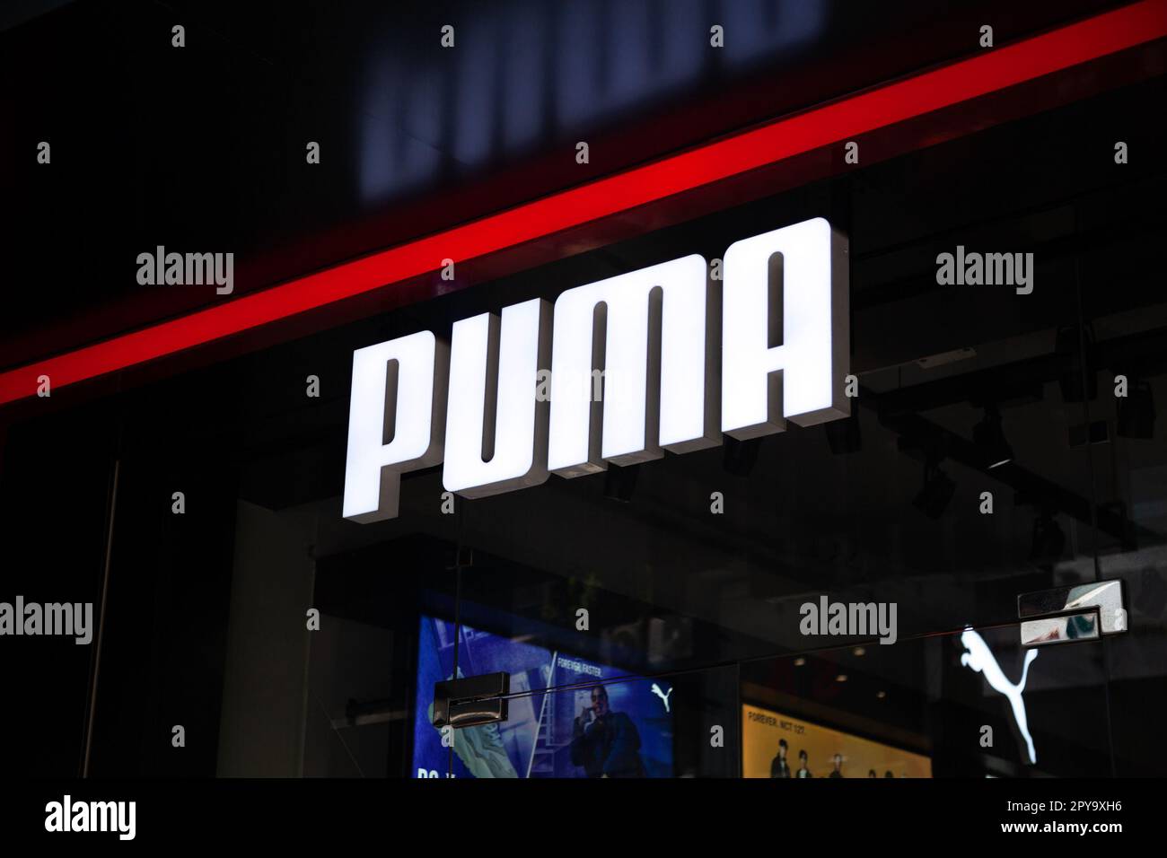 Ho Chi Minh City, Vietnam - May 1, 2023: Sportswear store business sign with a white Puma logo. Famous sport footwear brand logotype above a store ent Stock Photo