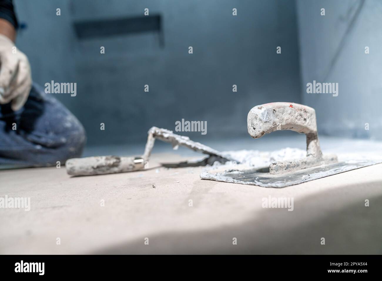 work with trowel on floor and wall in new room in building Stock Photo ...