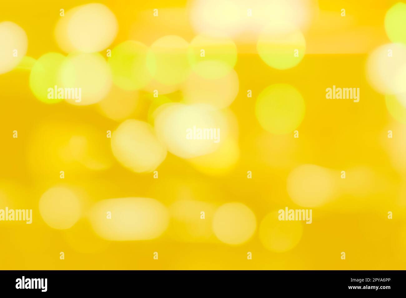Blurred yellow and golden bokeh background. Blur abstract background of yellow light. Yellow light with beautiful pattern of circle bokeh. Golden bokeh abstract background for festive decoration. Stock Photo
