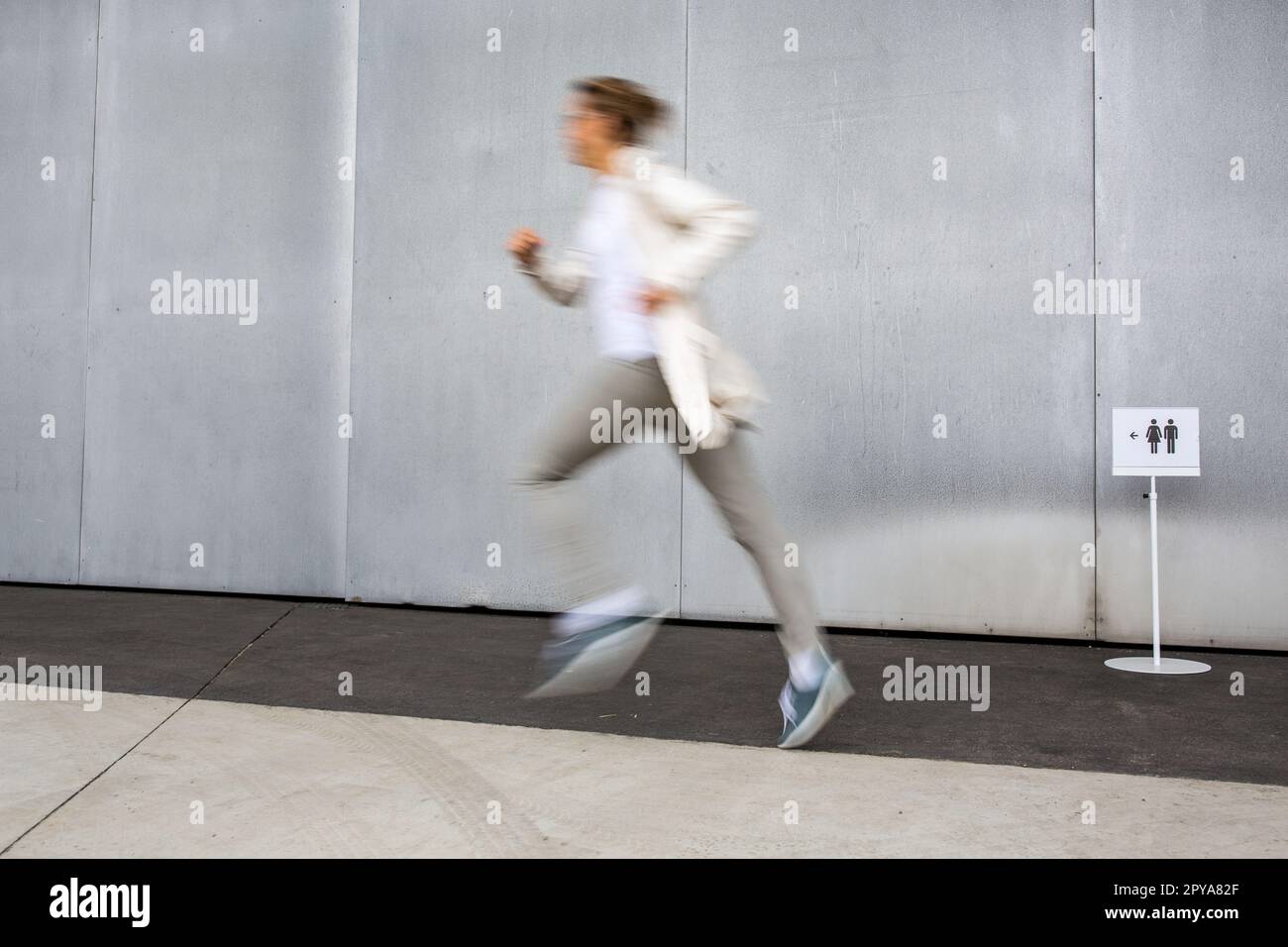 Woman rushing to a bathroom, toilet, hygiene, restroom. WC urgency concept. Stock Photo