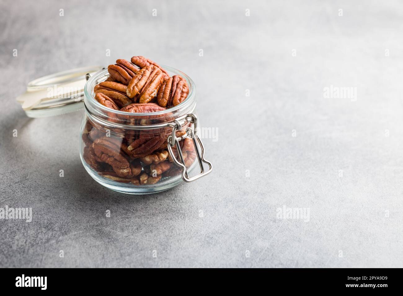 Peeled pecan nuts in jar on kitchen table. Stock Photo