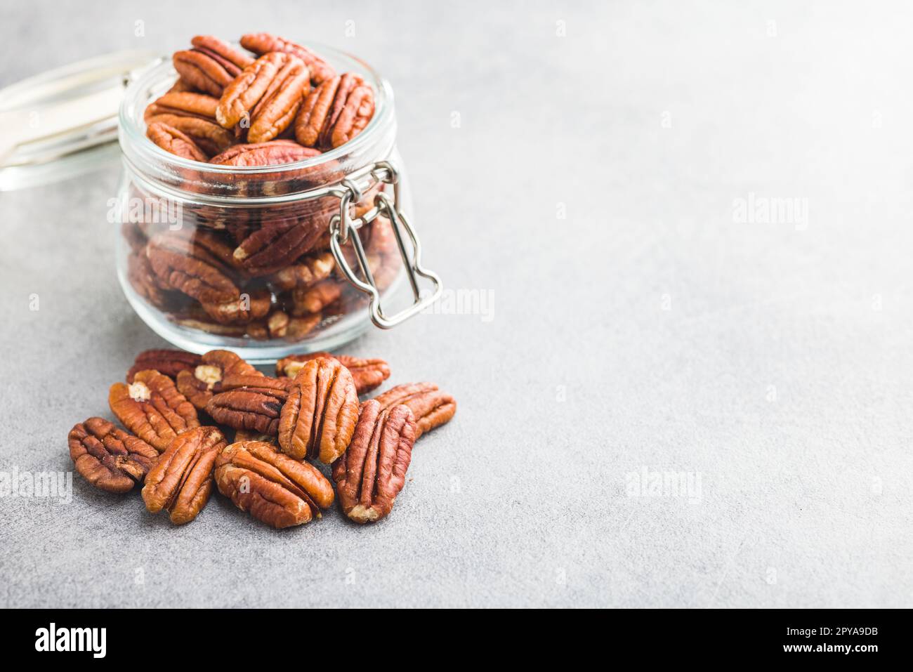 Peeled pecan nuts in jar on kitchen table. Stock Photo