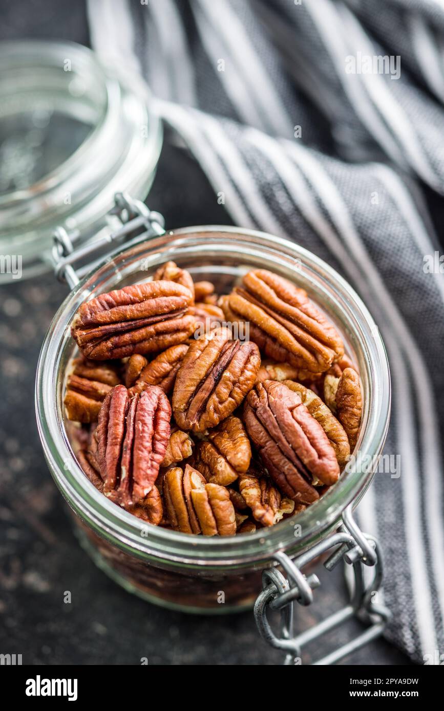 Peeled pecan nuts in jar on kitchen table. Stock Photo