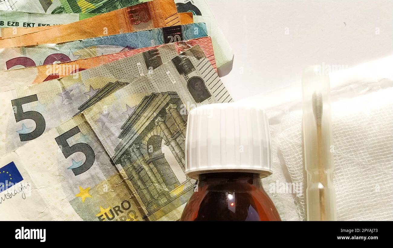 Euro paper notes. European currency on a white background close-up. A bottle of medicine and a measuring syringe next to money. The high cost of treatment. Bank notes for 5, 10, 20, 50 and 100 Stock Photo