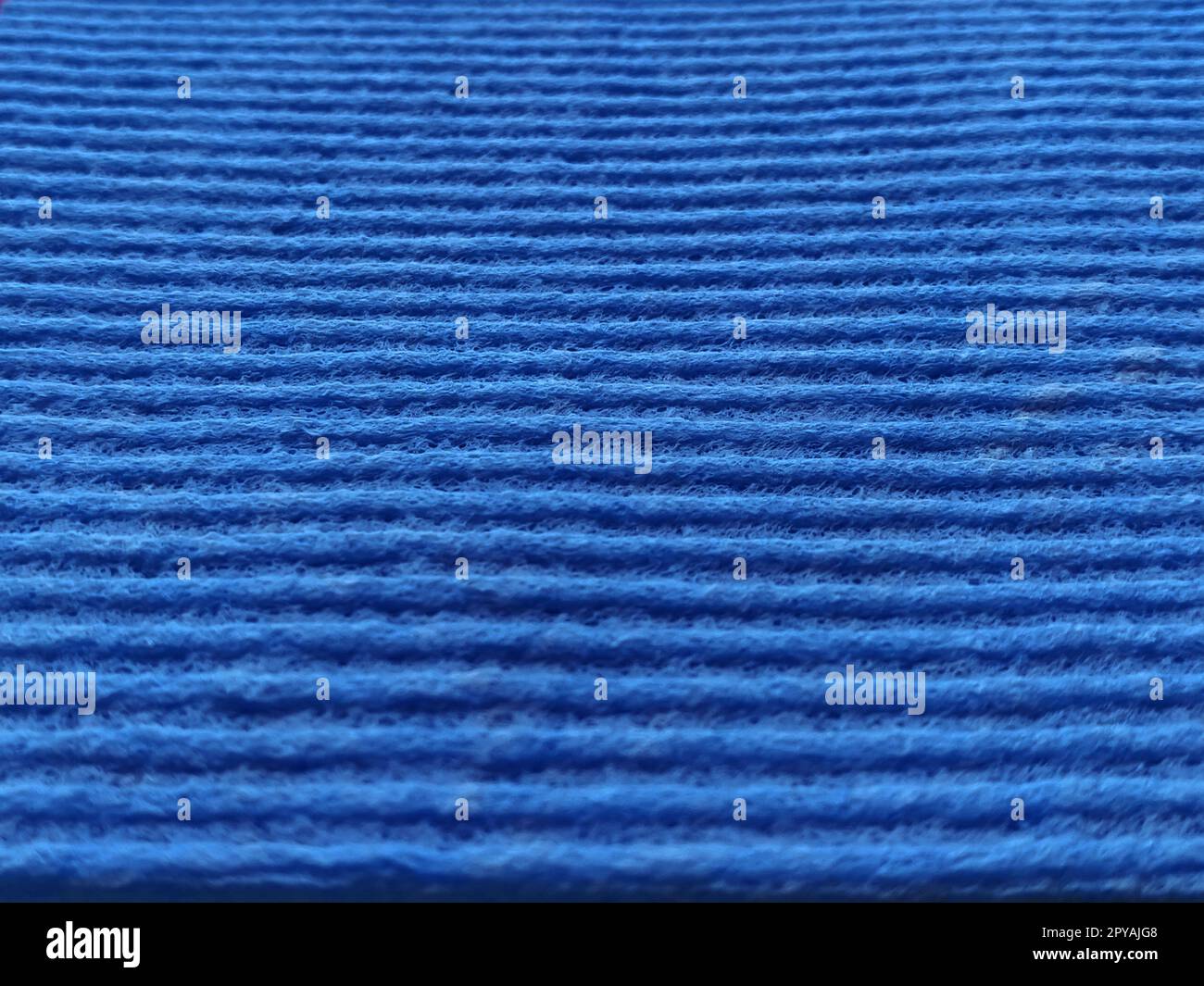 Blue striped ribbed fabric. Close-up shot of a dish washing sponge or microfiber cloth. Blur around the edges Stock Photo