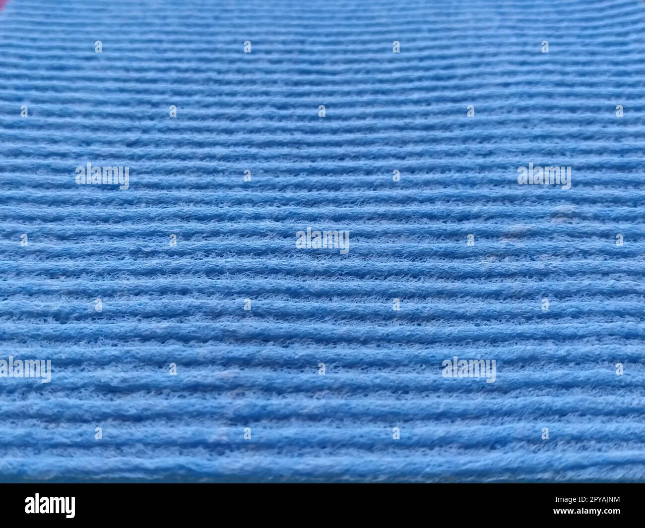 Blue striped ribbed fabric. Close-up shot of a dish washing sponge or microfiber cloth. Blur around the edges Stock Photo