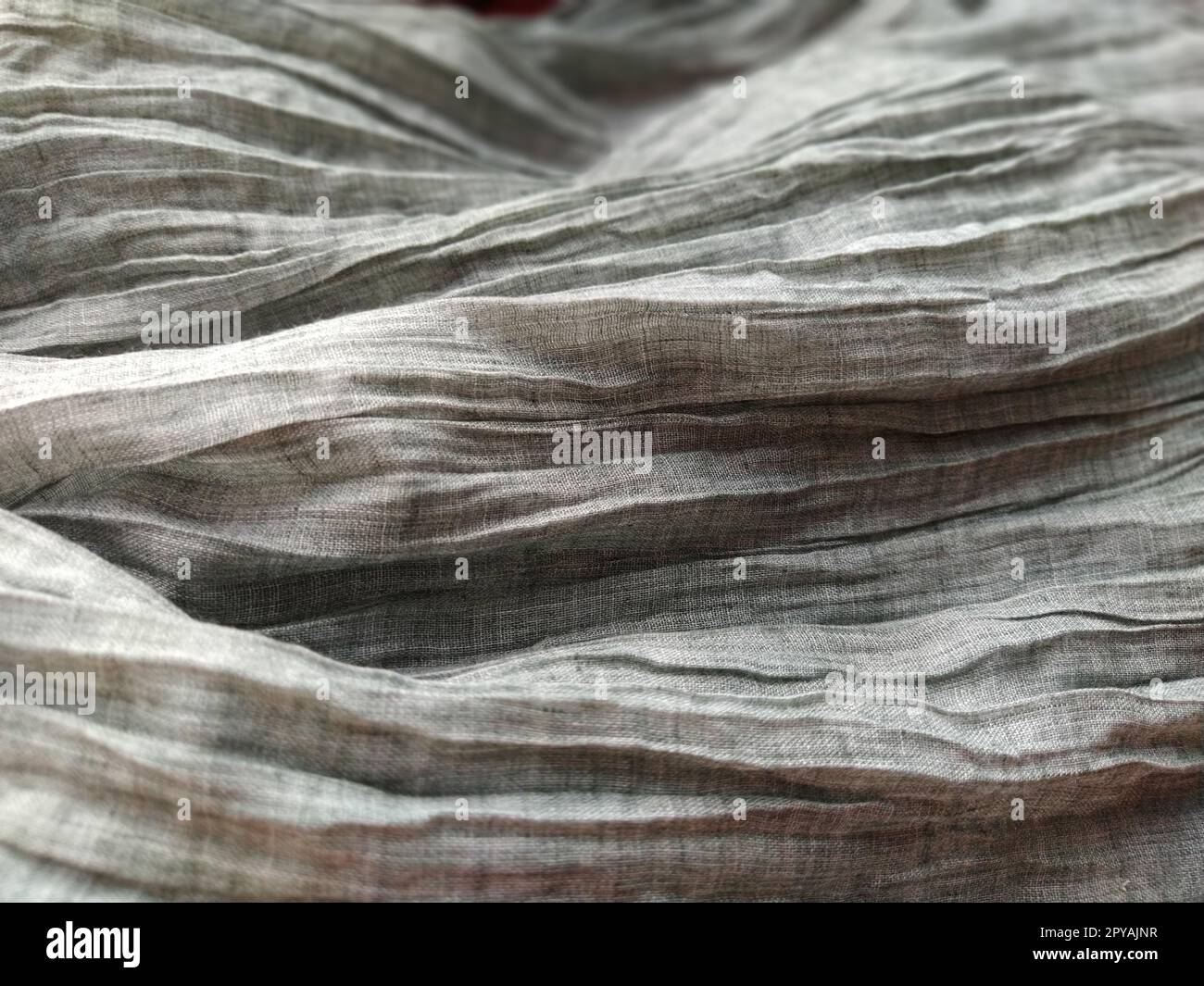 Fabric sheer curtain fabric. Beautiful gray color. The curtain material is carelessly folded and wrinkled. Fabric sample. Interior design option. Stock Photo