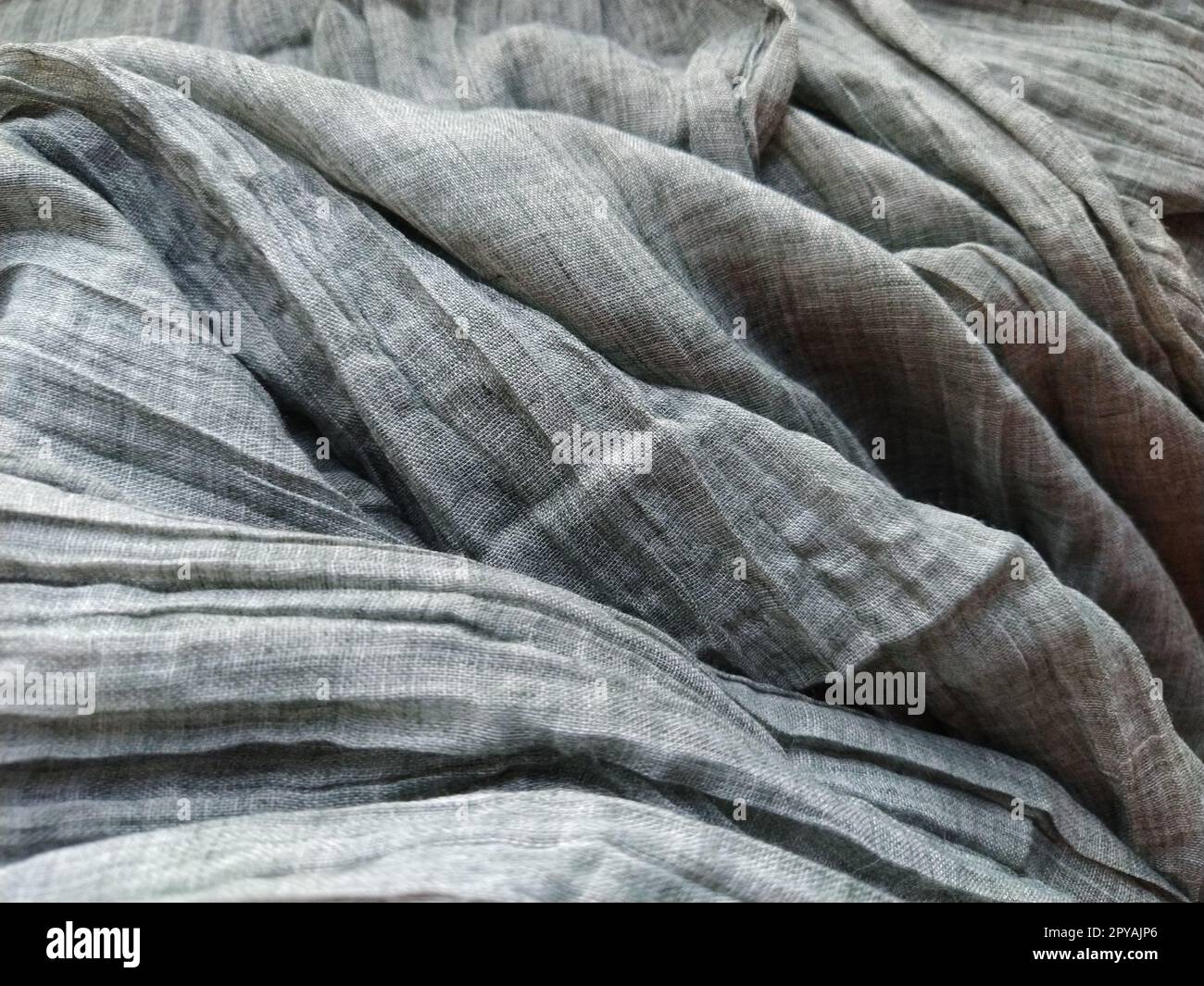 Fabric sheer curtain fabric. Beautiful gray color. The curtain material is carelessly folded and wrinkled. Fabric sample. Interior design option. Stock Photo