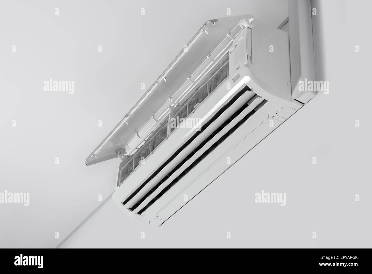 Modern air conditioner on white wall indoors Stock Photo - Alamy
