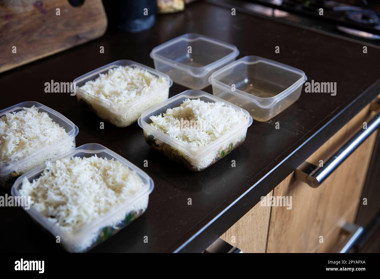 Meal prep. Stack of home cooked rice and chicken dinners in containers ready to be frozen for later use as quick and easy ready meals. Food prepping for healthy dieting Stock Photo