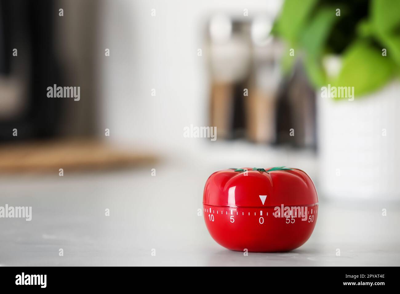 Kitchen timer in shape of tomato on white table indoors. Space for text ...