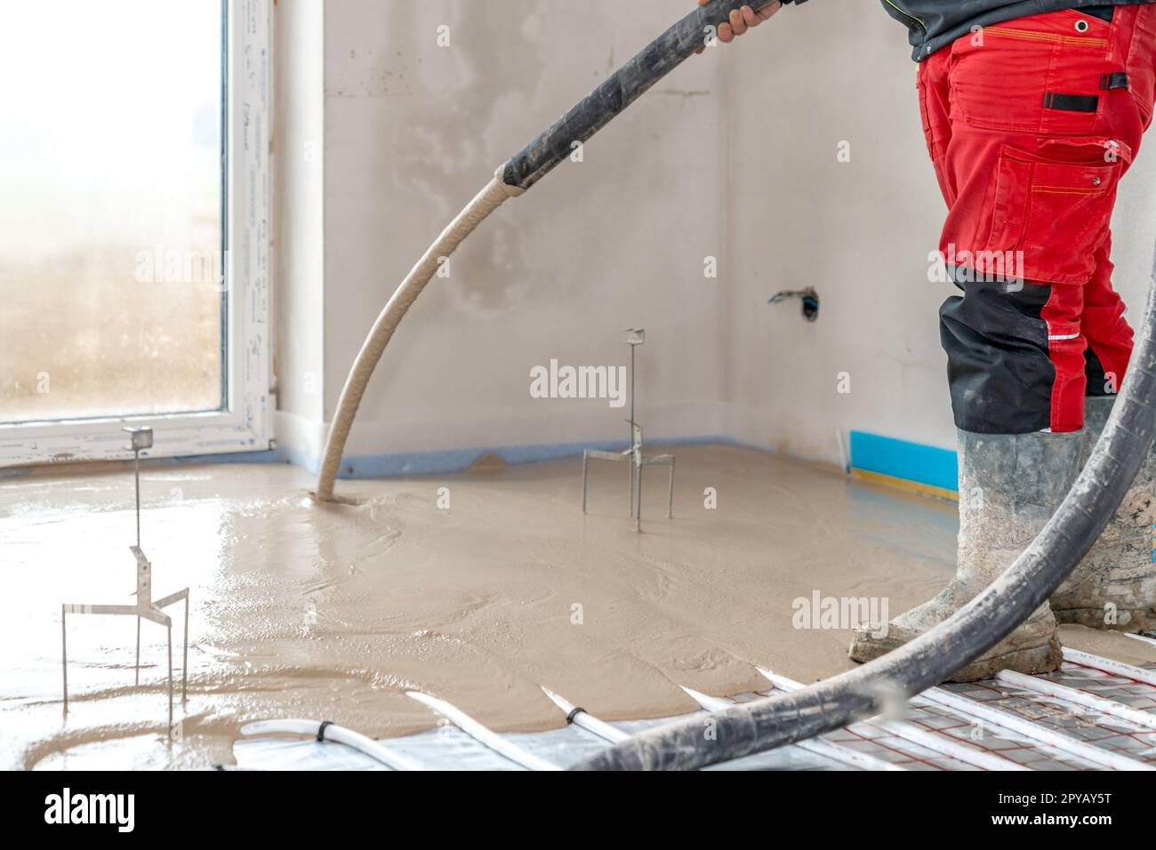 installation of liquid concrete on the floor for underfloor heating Stock Photo