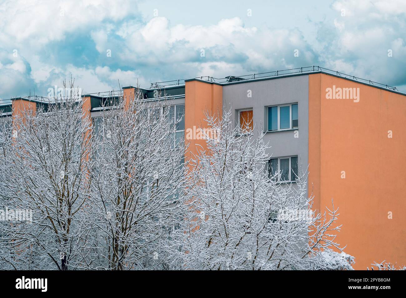 Winter landscape of frosty trees and multi story house Stock Photo
