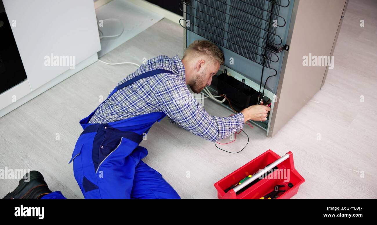 Testing Electric Appliance Using Multimeter To Repair Fridge Stock Photo