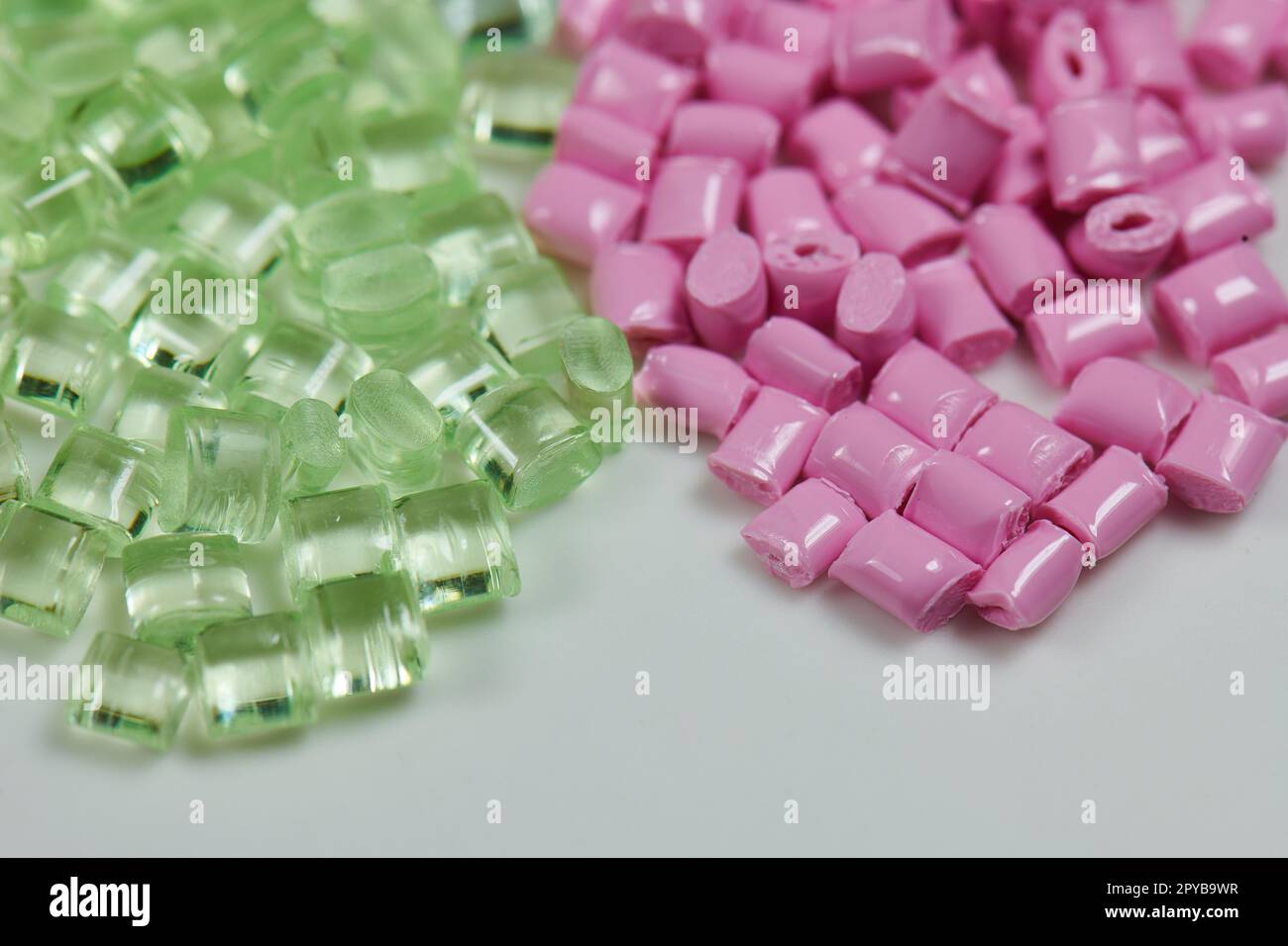 pink and green transparent polymer resin granulates for injection molding and extrusion Stock Photo