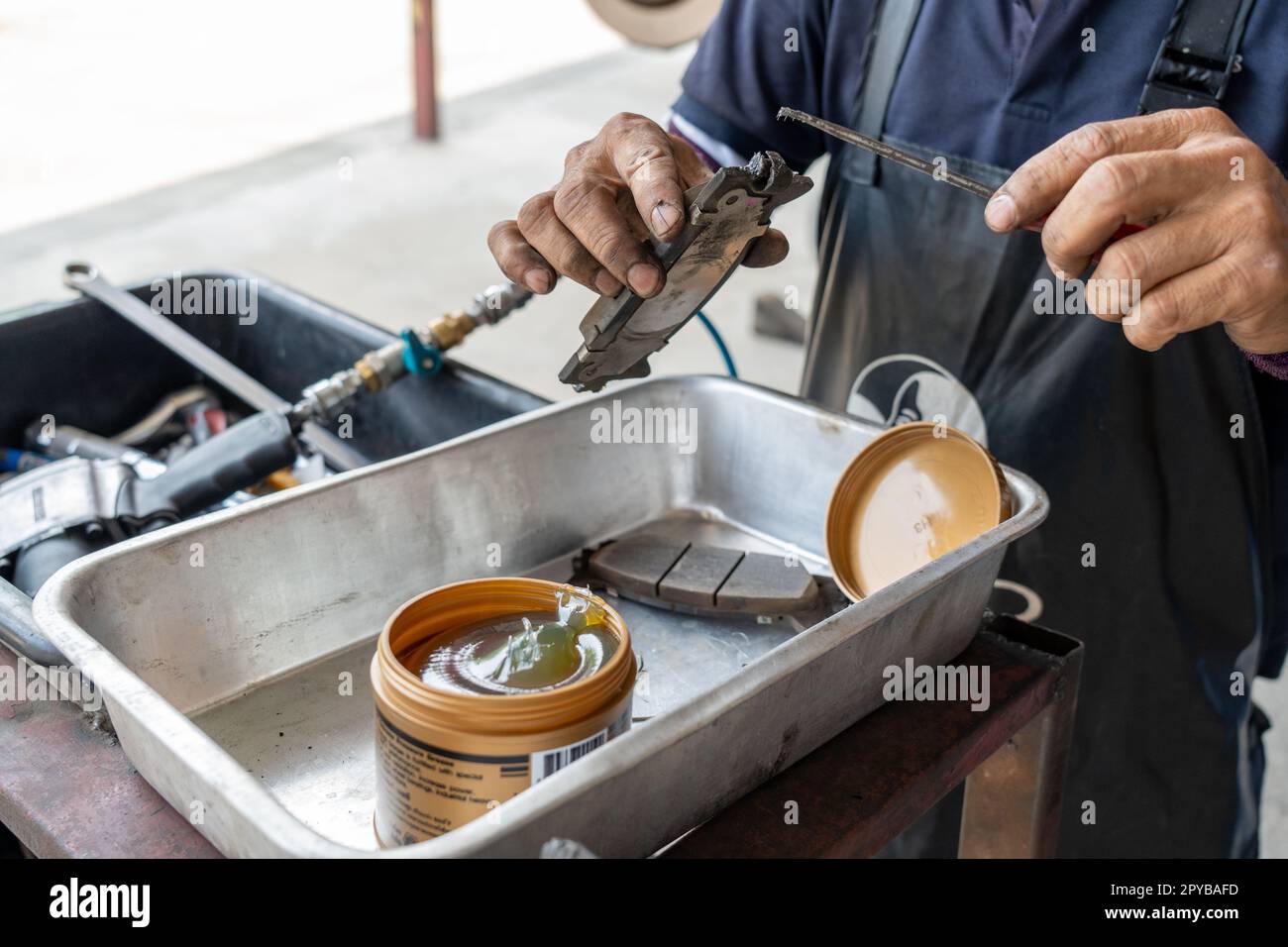 Auto mechanic putting lubricating grease oil on the break shoe before