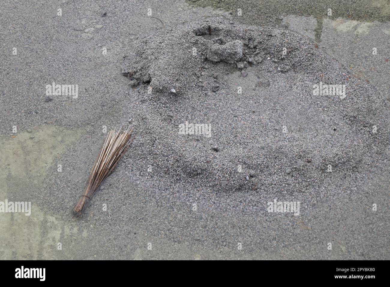 M sand pile on a construction site with a broomstick by the side Stock