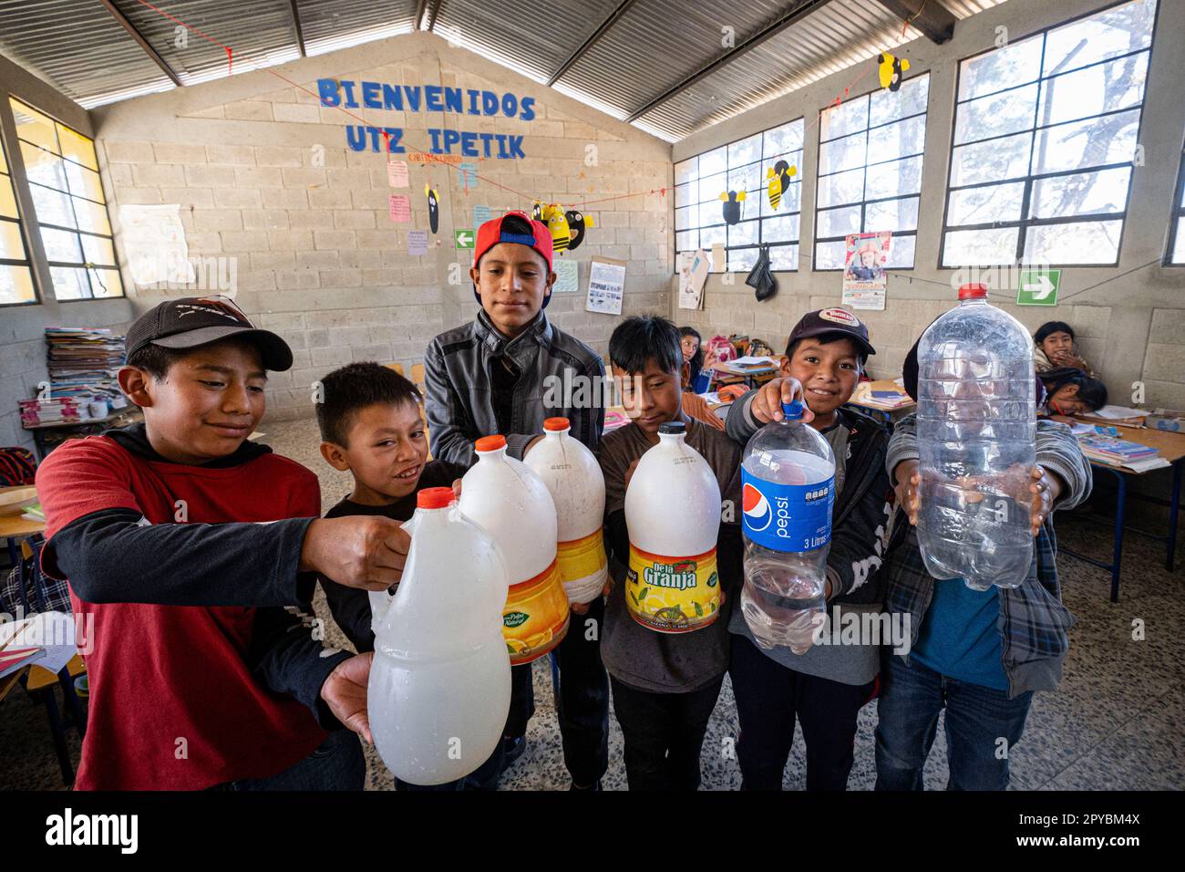 niños con garrafas de agua potable, escuela de primària, Patzojón Chiquito, Quiche, Guatemala, America Central Stock Photo