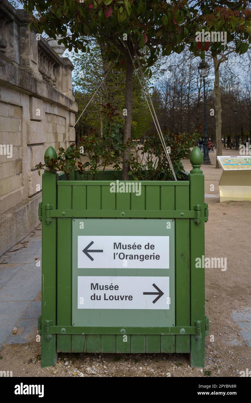 A sign pointing to Musée de l'Orangerie and Musee du Louvre in Jardin des Tuileries (Tuileries Garden) in Paris, France. Stock Photo