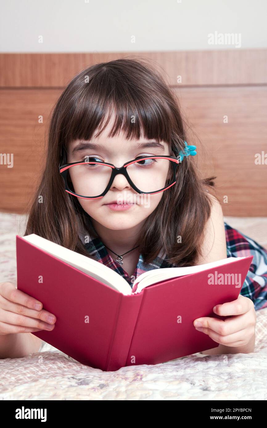 Little girl reading a book at home Stock Photo - Alamy