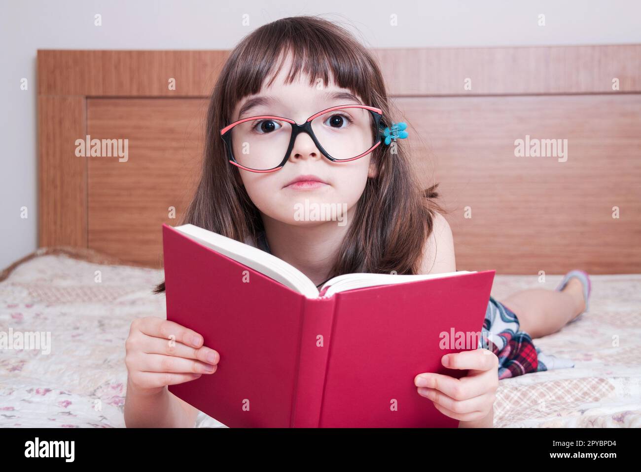 Little girl reading a book at home Stock Photo - Alamy