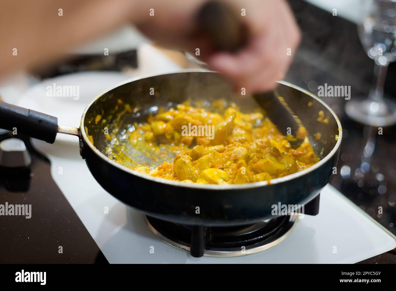 Traditional way of preparing indian food mushroom curry using gas pan