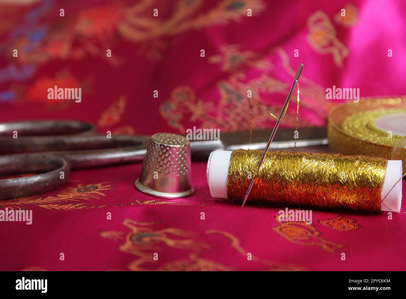 Spool of Pink Thread and Thimble on Vintage Pink Satin and Feather Fabric  Stock Photo - Alamy