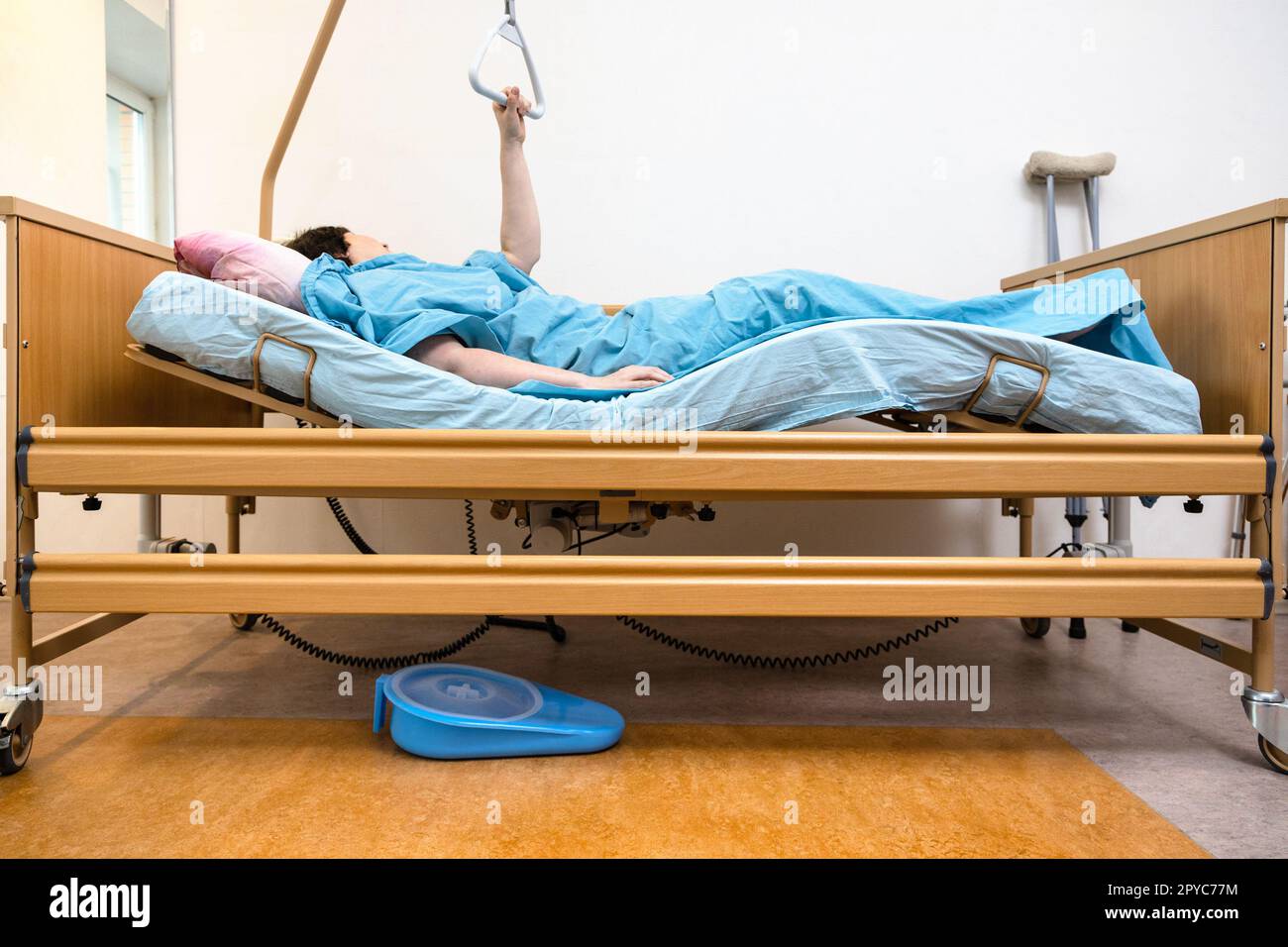 curved hospital bed with patient holding handle Stock Photo Alamy