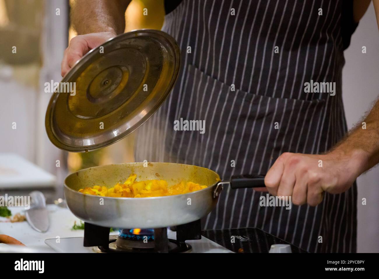 Traditional way of preparing indian food aloo gobi (potatoes with cauliflower) using gas pan