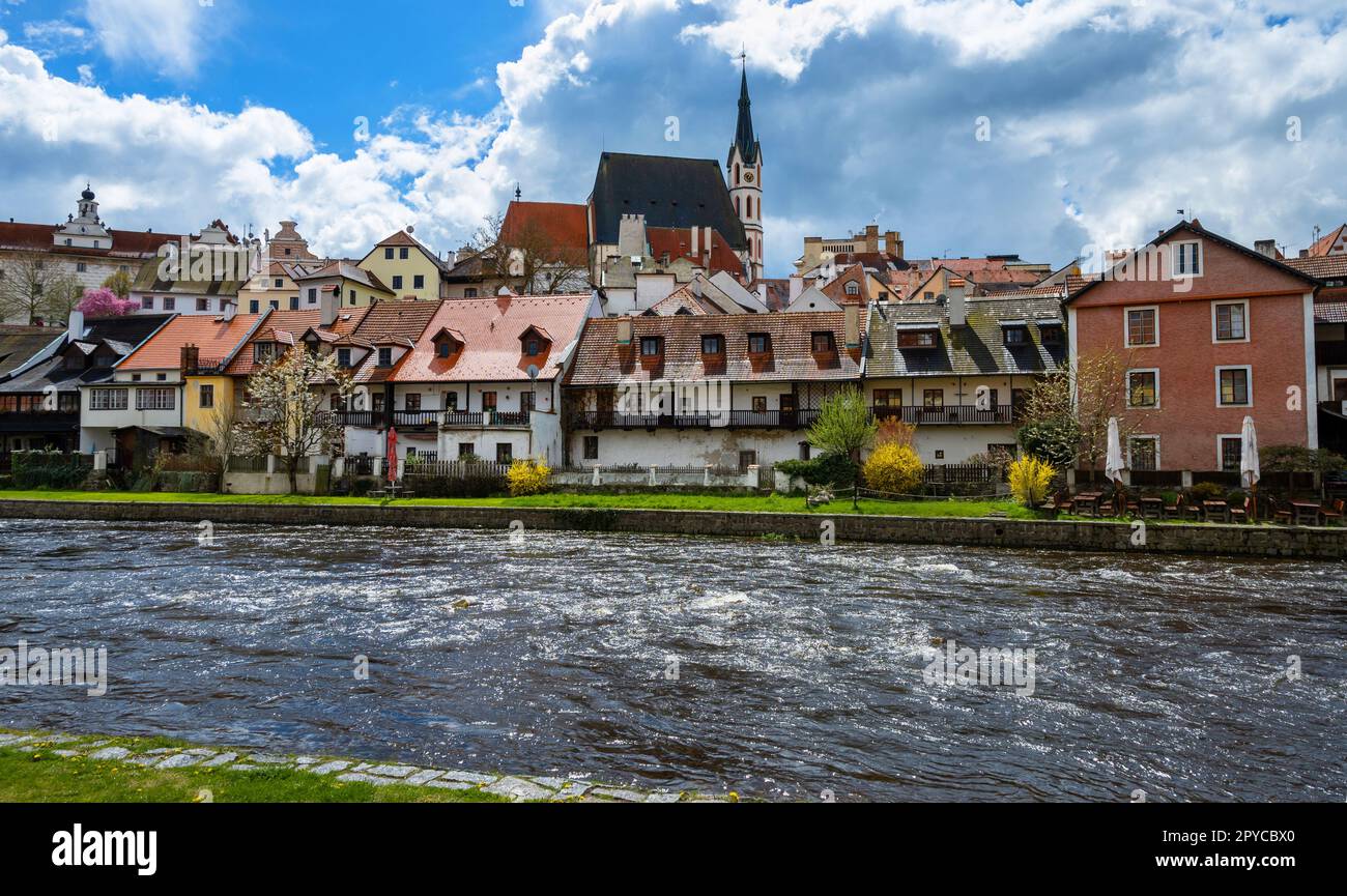 Panorama with picturesque historical building on embankment of Cesky Krumlov, river Vltava and Church of St. Vitus on background, Czech republic. Stock Photo