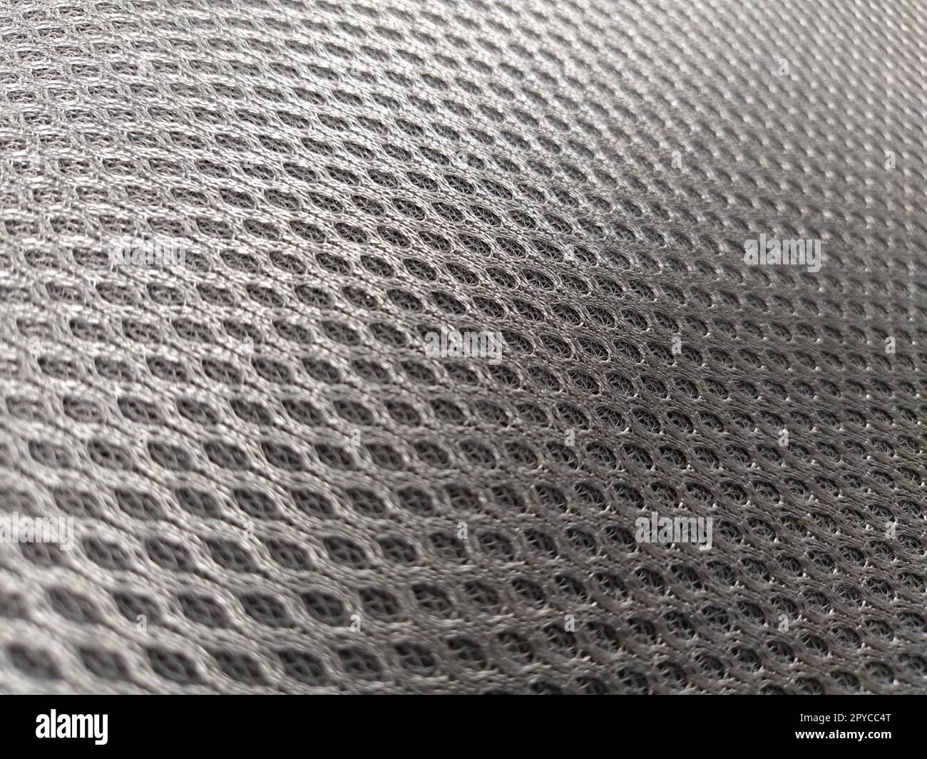 Abstract black nylon synthetic fabric. Gray artificial fabric mesh, resistant to pollution. Fragment of a child car seat close-up. Soft focus Stock Photo