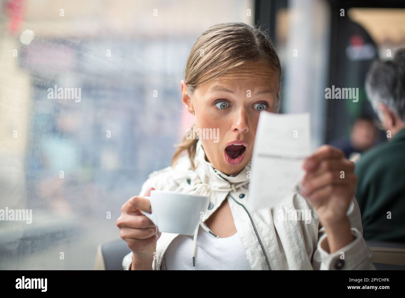 Pretty, young woman baffled with the bill in a Stock Photo Alamy