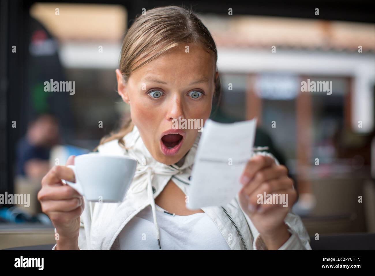 Pretty, young woman baffled with the bill in a Stock Photo Alamy