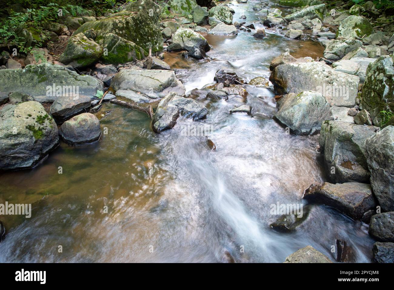 Grey Ridge Streams Closeup of long exposure stream flowing around large gray stones Stock ...