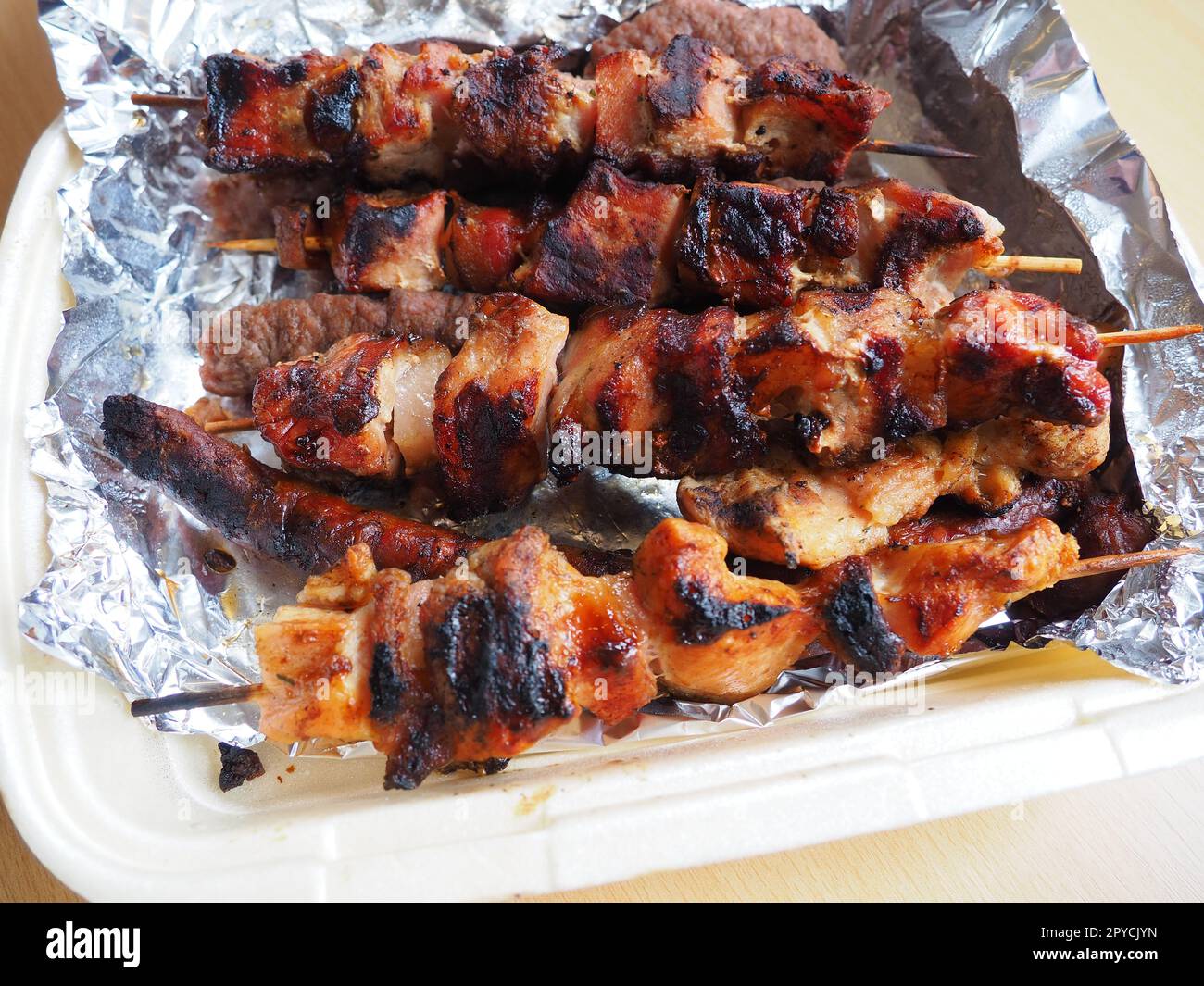 Grilled meat in disposable packaging and aluminum foil, delivered from