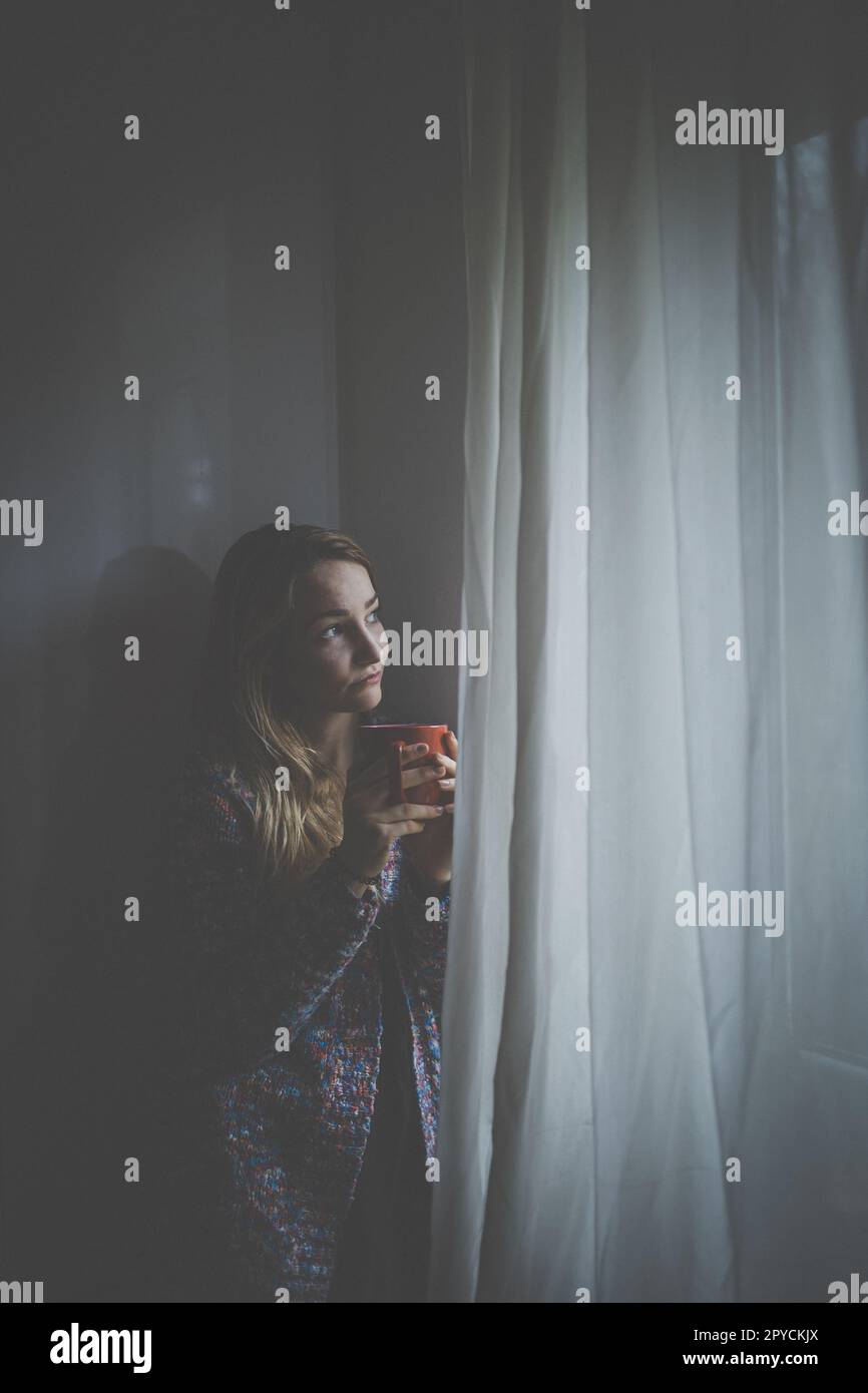 Cold, depressed, young woman at home feeling sad, lonely, anxious (color toned image) Stock Photo