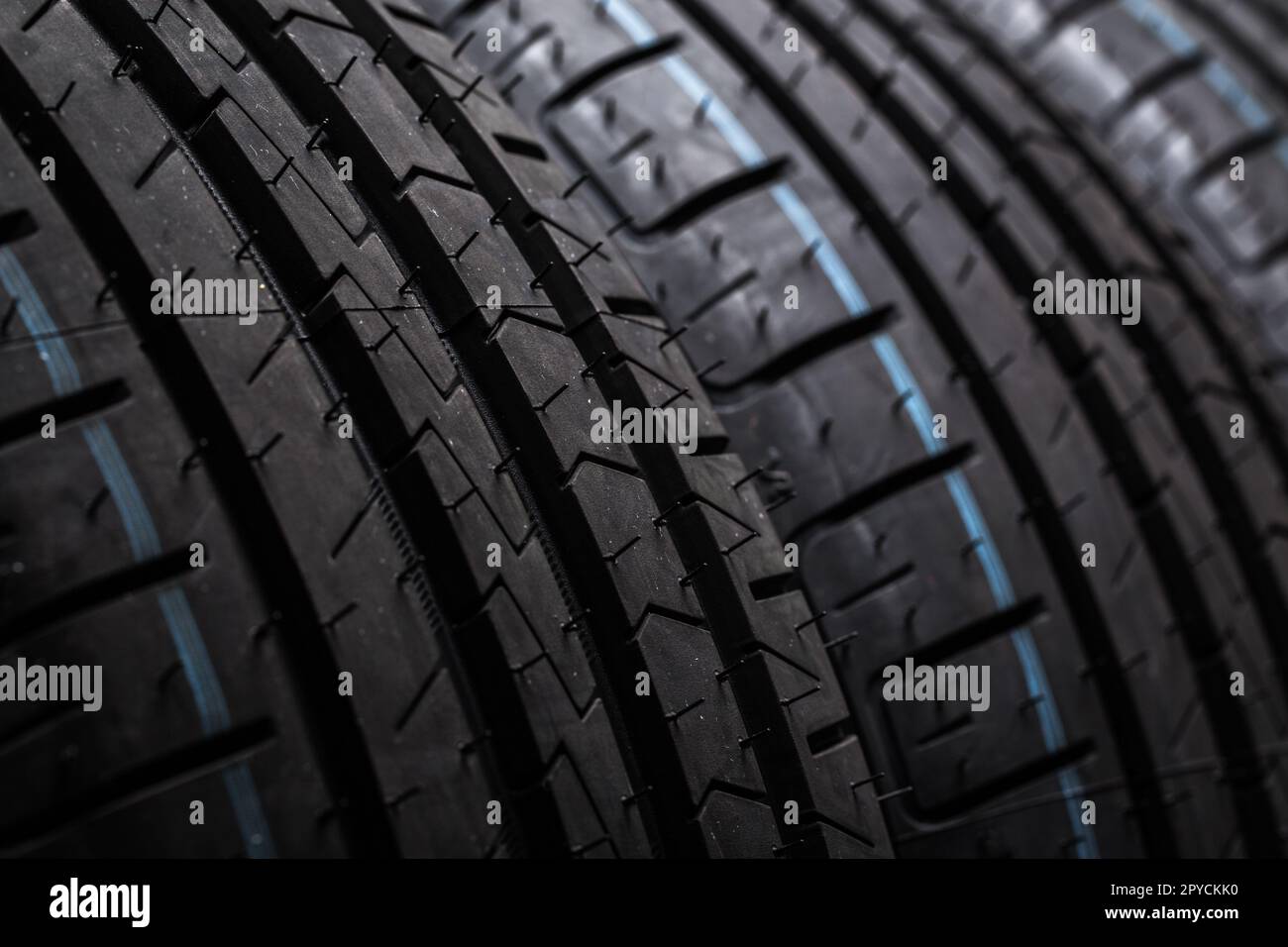 Stack of brand new high performance car tires on clean highkey white