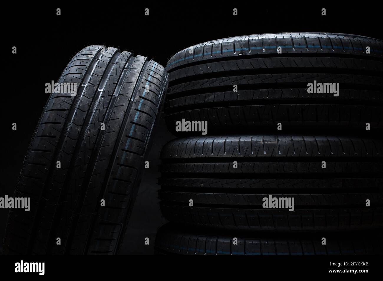 Stack of brand new high performance car tires on clean highkey white