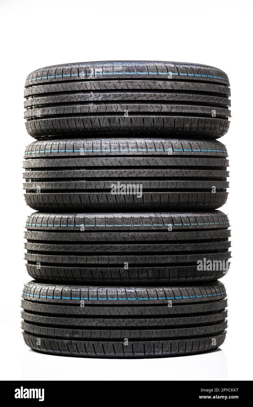 Stack of brand new high performance car tires on clean highkey white