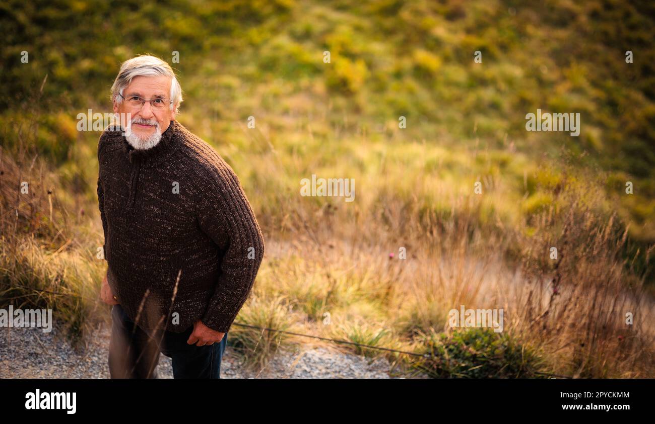 Elderly caucasian male walking outdoors on an autumn, fall day Stock Photo